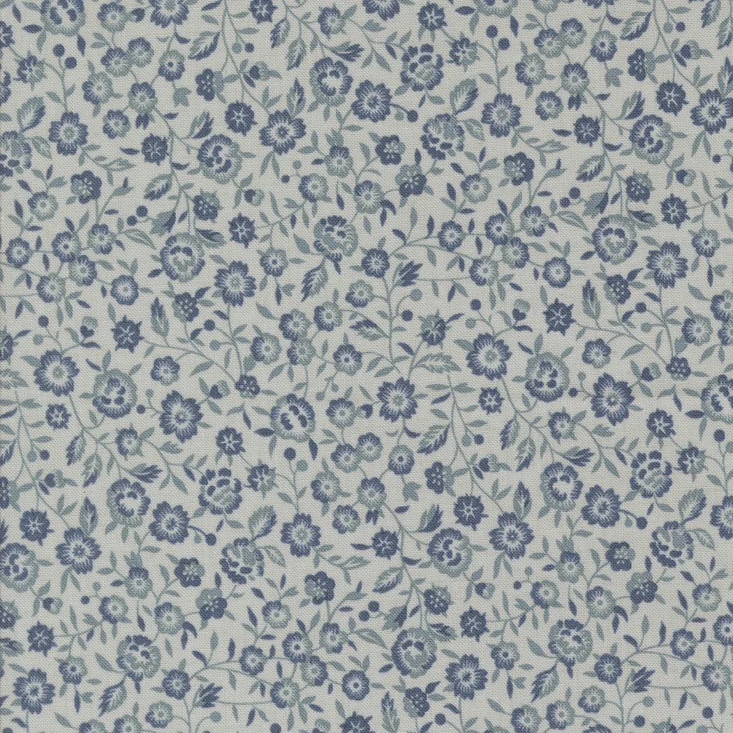 Close-up of light fabric with a pattern of small, dark blue flowers and green leaves.