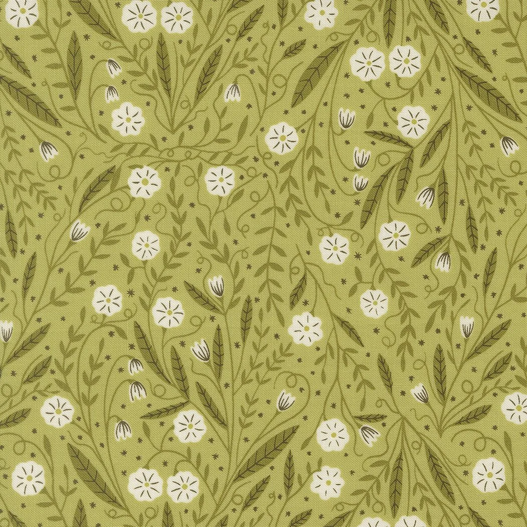 Green fabric with a floral pattern of white and dark brown flowers, leaves, and swirling vines.
