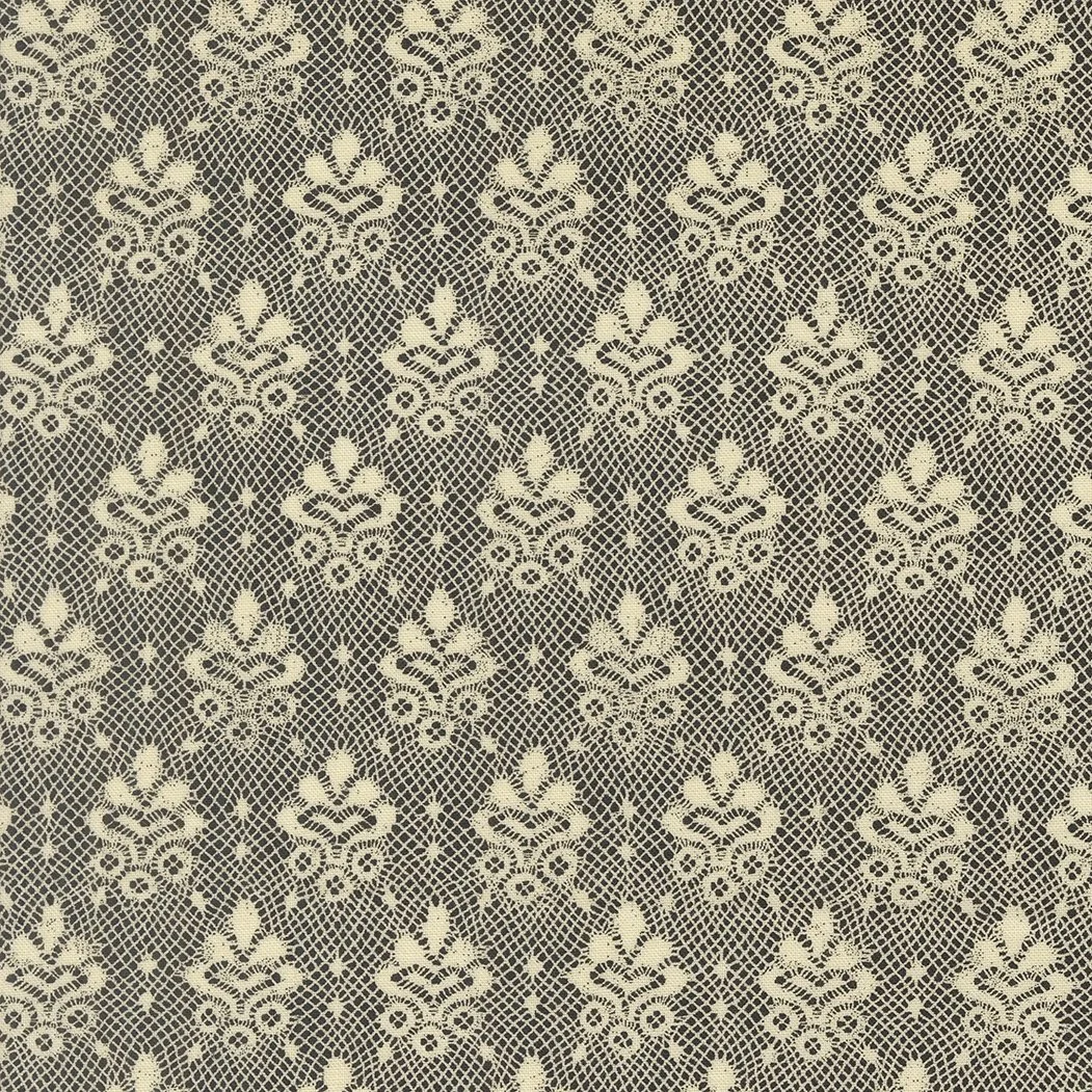 Close-up of beige lace fabric with floral and geometric patterns.