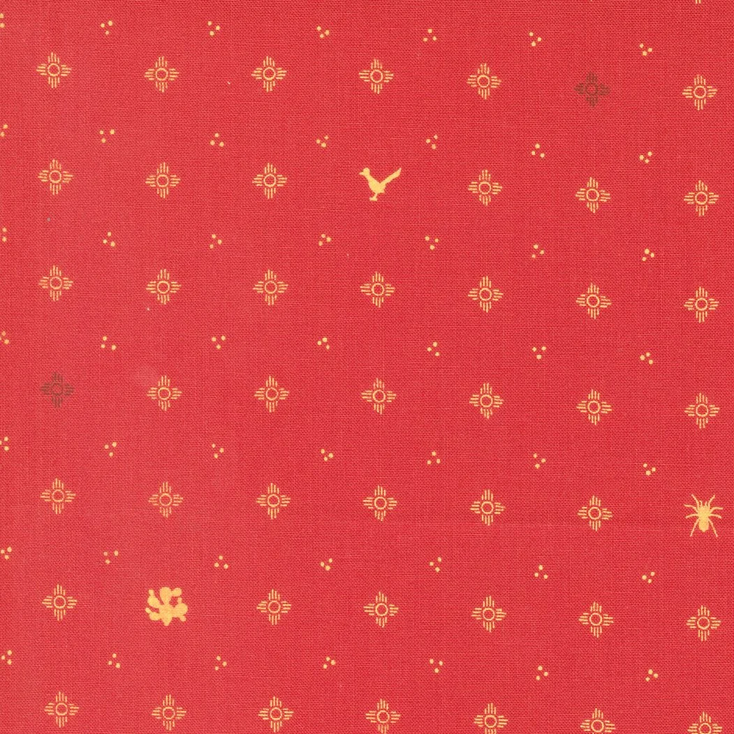 Red textile fabric with small yellow geometric floral designs, small yellow dots, a small dark cloudy mark, and a yellow star-shaped emblem in the bottom right corner.