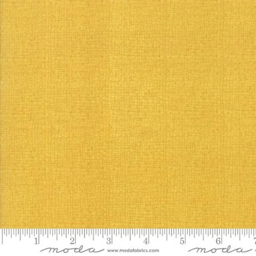Close-up of yellow textured fabric with a ruler at the bottom.