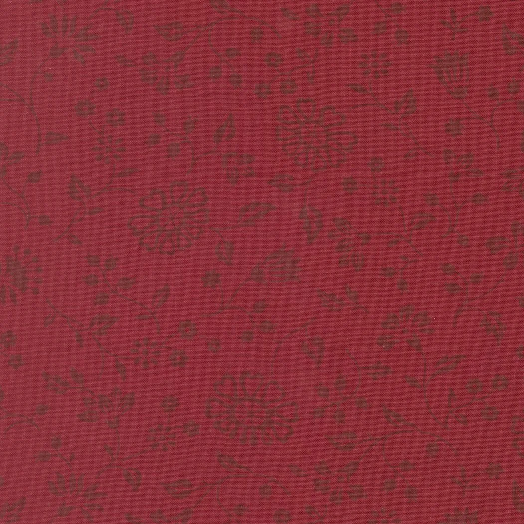 Red fabric with a dark floral pattern.