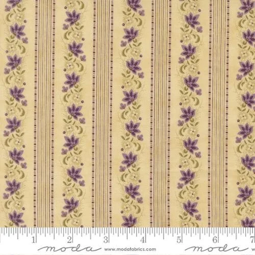 Close-up of fabric with yellow background, purple floral pattern, and striped accents, including a ruler at the bottom for scale.