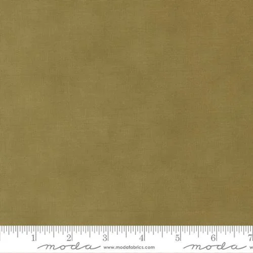 A plain, solid-colored beige fabric swatch with measurement markings along the bottom.