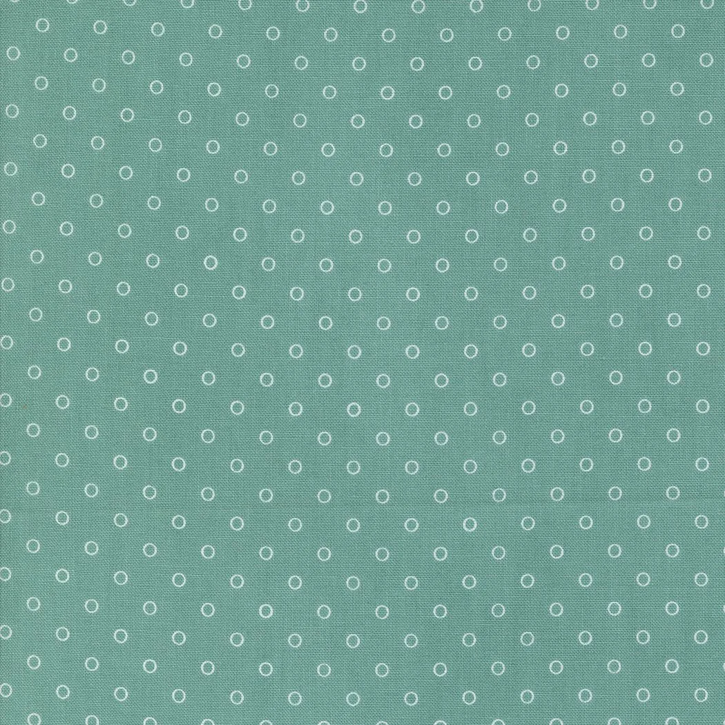 Close-up of teal fabric with small white circle pattern.