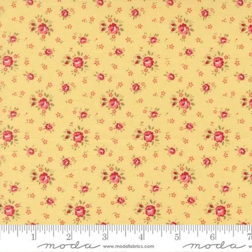 A yellow fabric with a floral pattern of pink roses and small red and pink flowers.