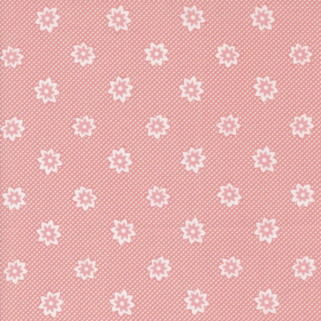 Pink fabric with white floral patterns and dotted background.