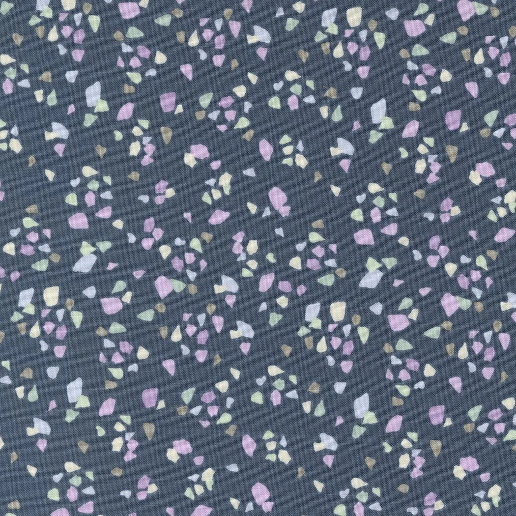 Close-up of fabric with a dark background and small, multicolored abstract shapes in pink, purple, light green, cream, and beige.