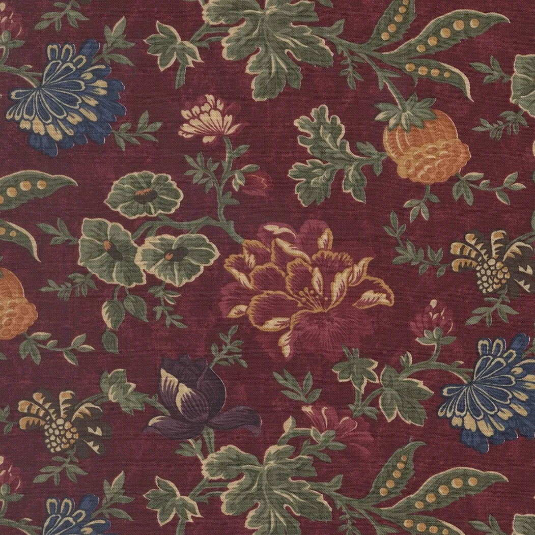 Close-up of a floral fabric with green leaves, yellow, purple, and peach flowers, on a dark red background.