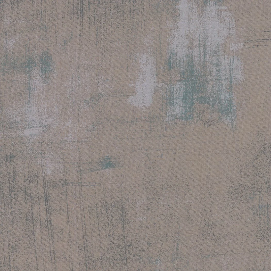 A textured beige carpet with abstract paint splatter and brushstroke markings in shades of blue, white, and gray.
