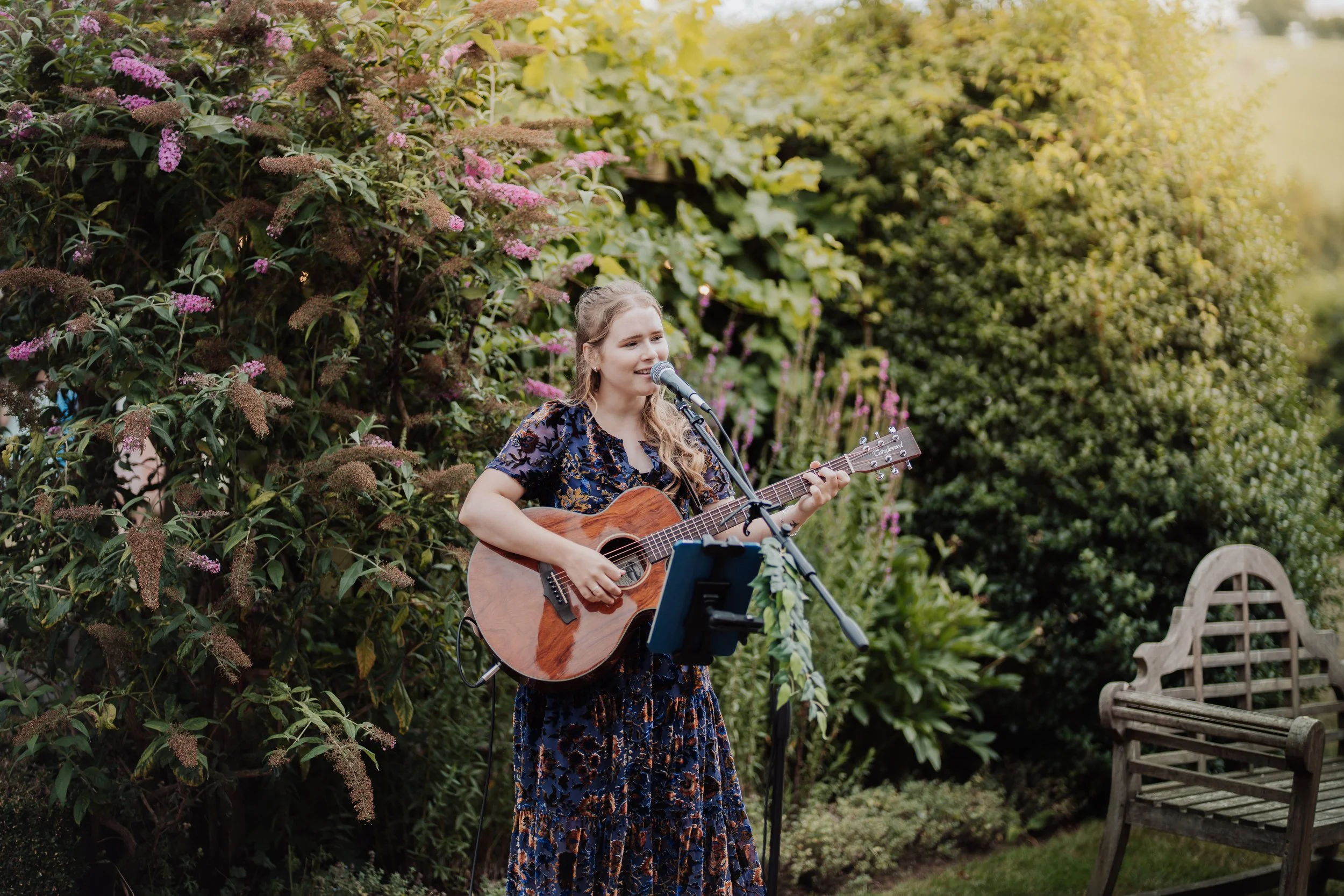 Poppy rose singing outdoors with acoustic guitar