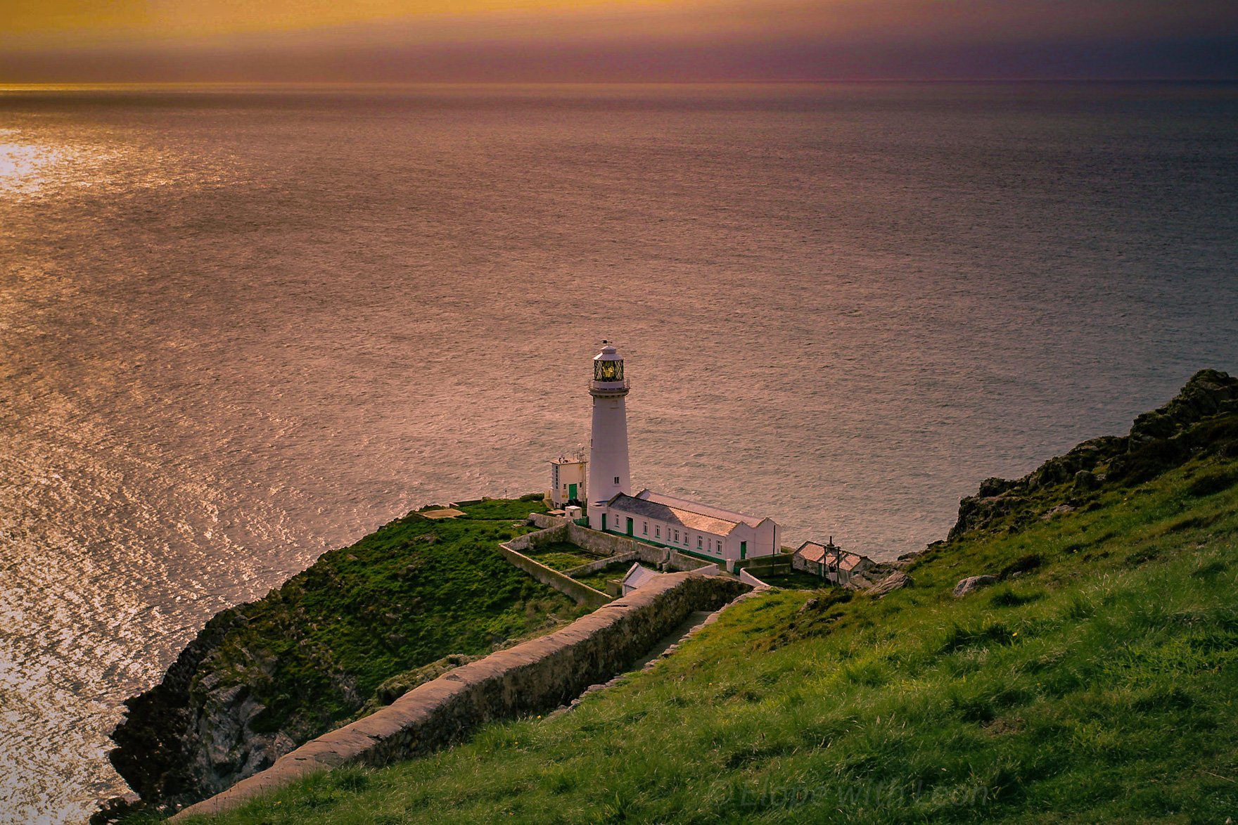 South Stack Lighthouse on a clifftop at sunset