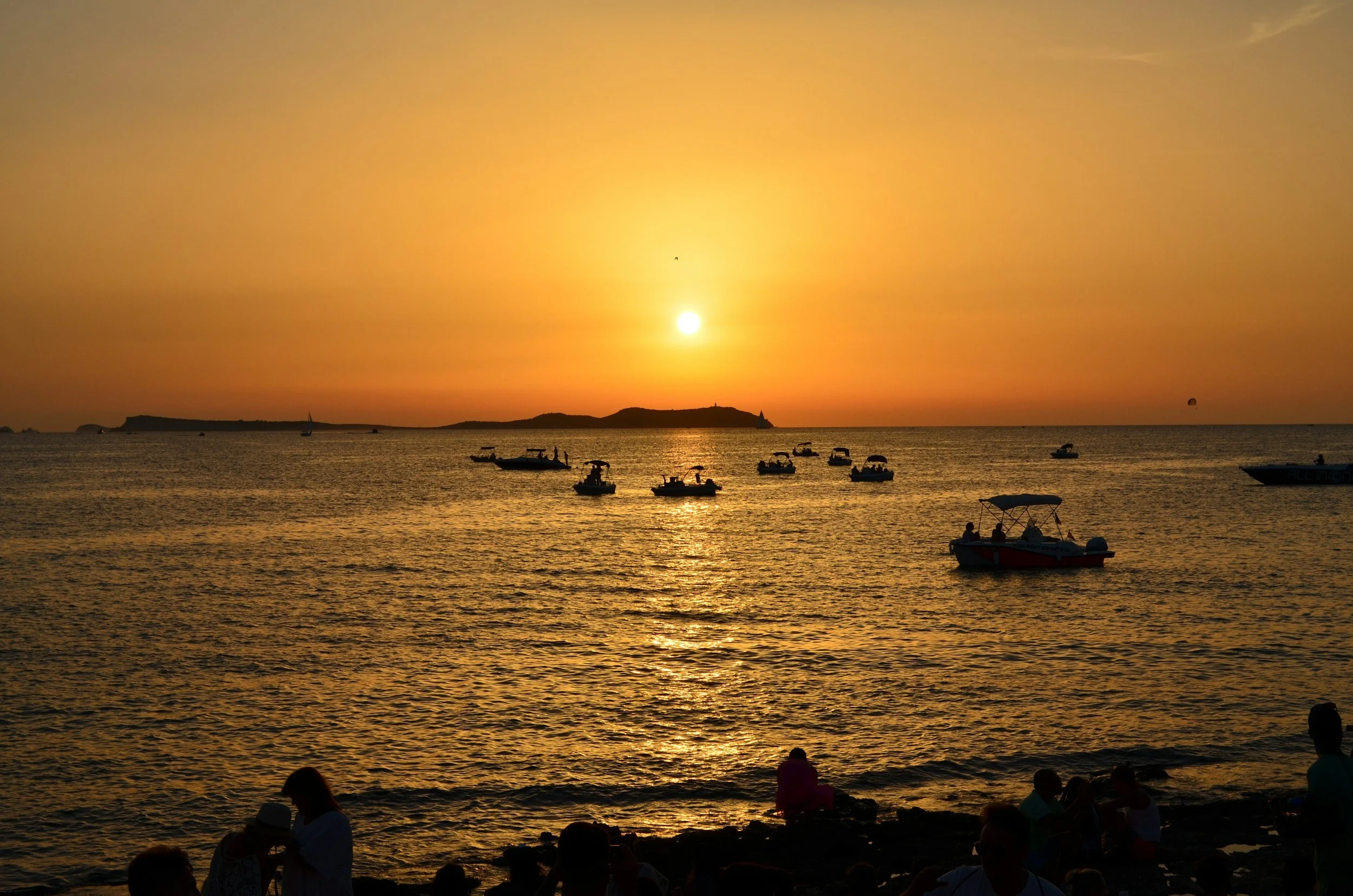 Sun setting over a bay with boats