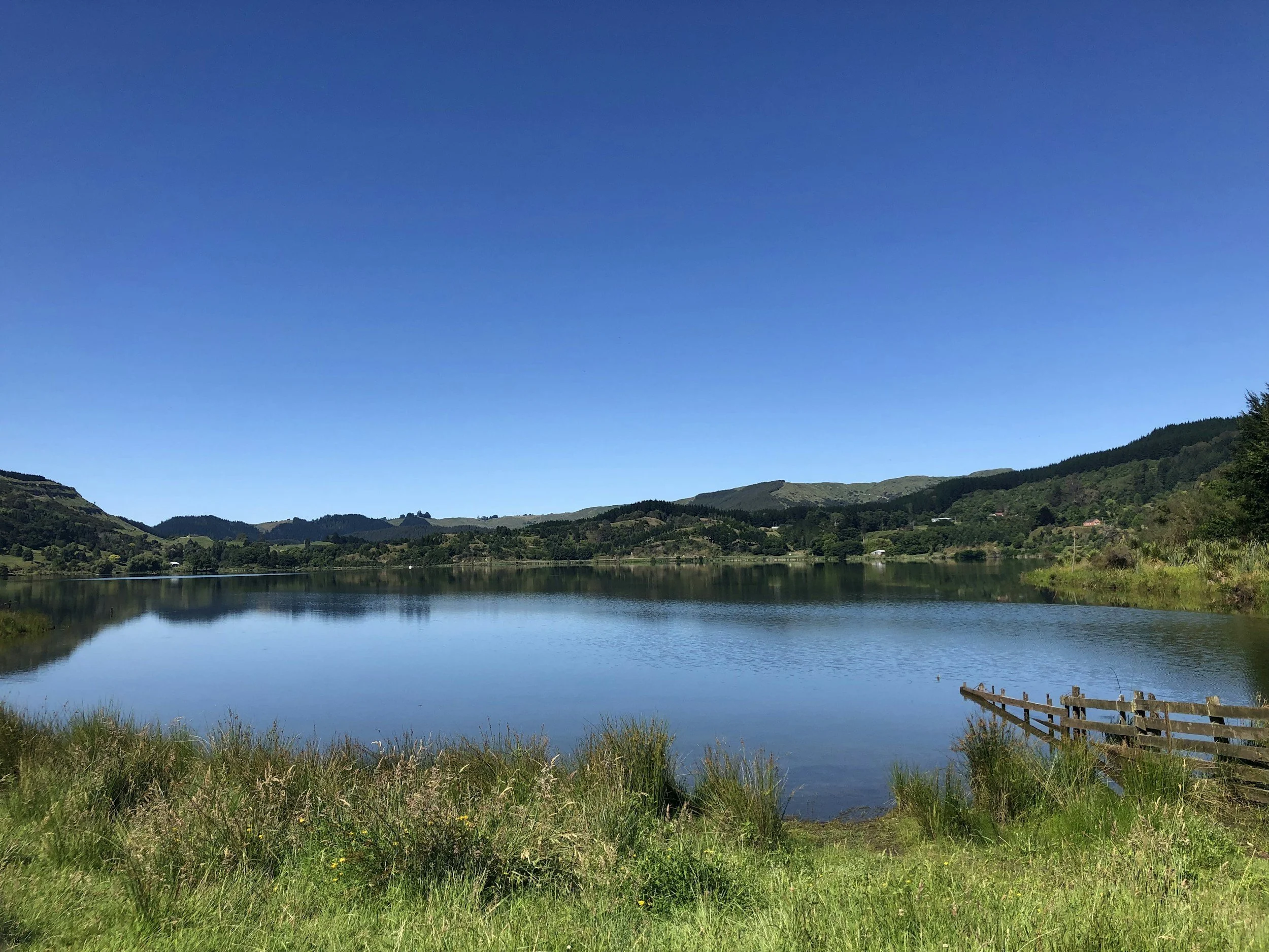 Hills reflected in a still lake on a calm day