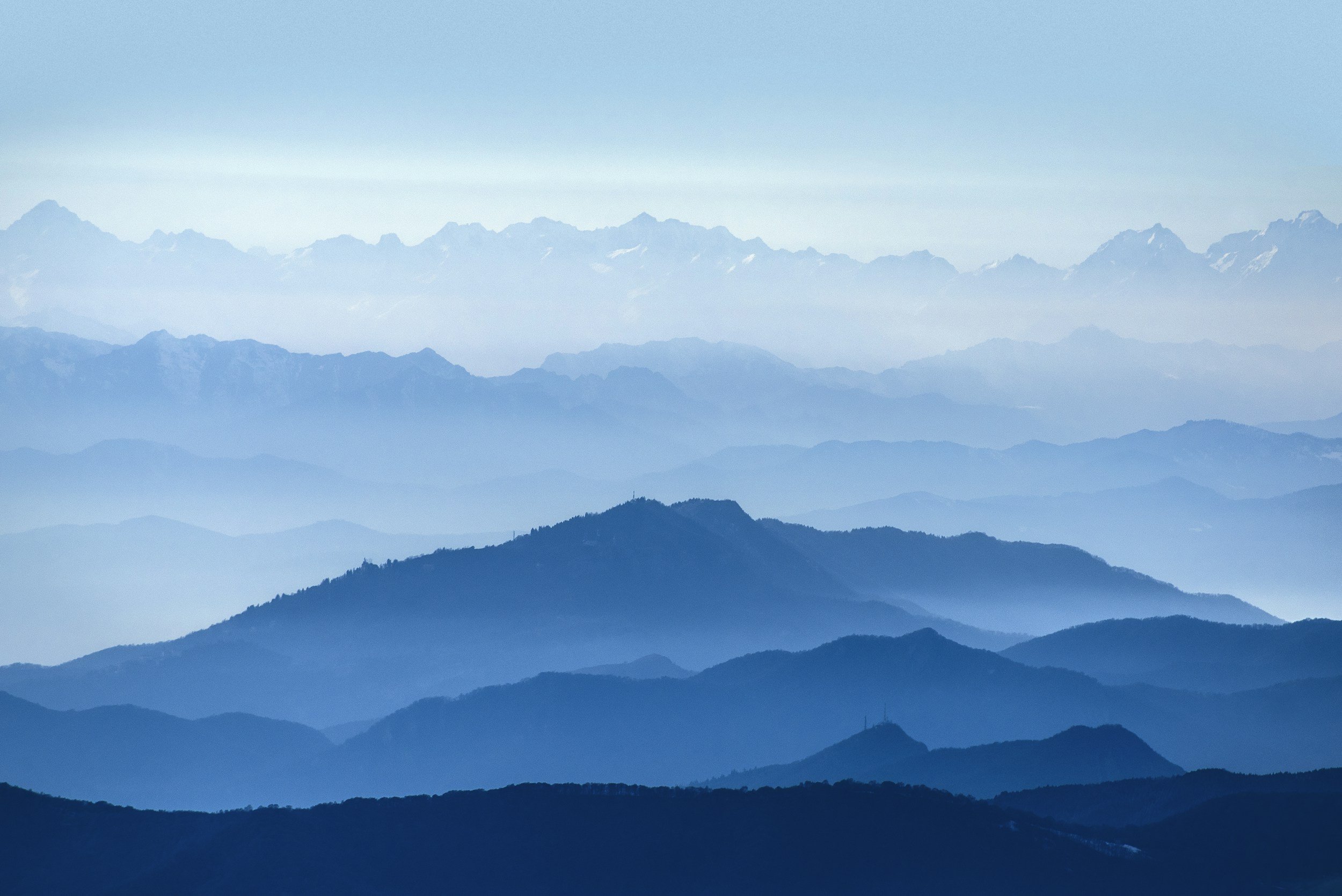Misty mountains at first light with layers of hills fading into the distance