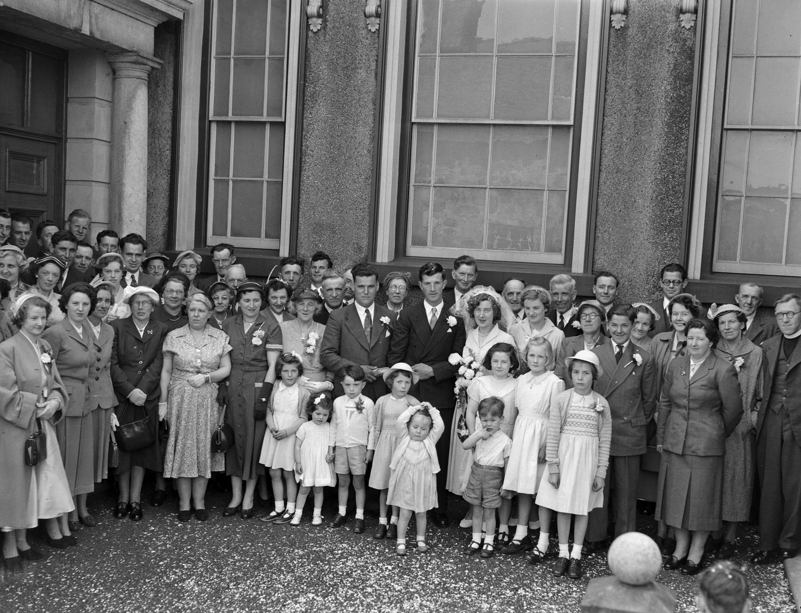 An old black-and-white photograph of a wedding party outside a building in Dolgellau