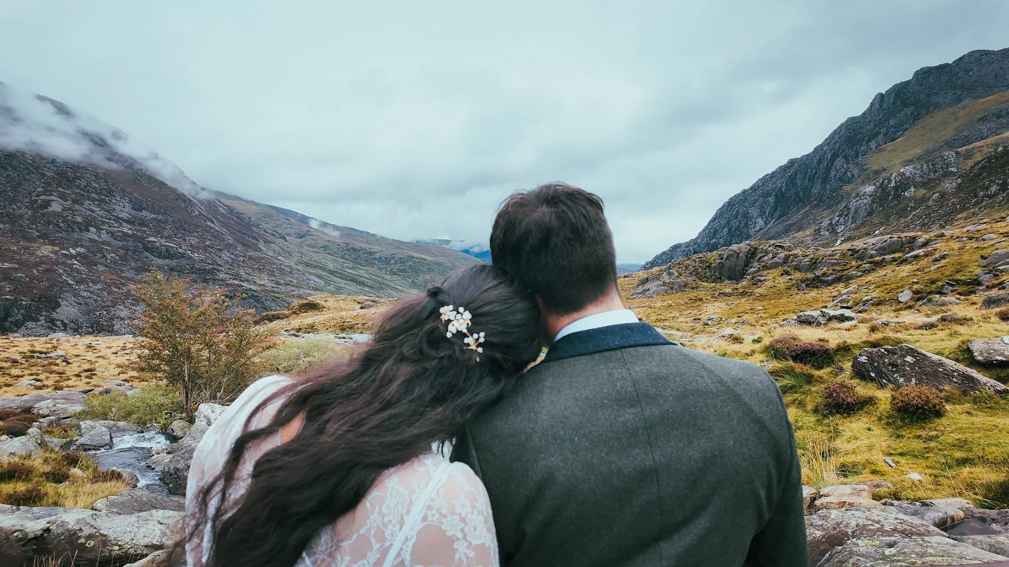 Couple seen from behind, looking out over a mountain valley