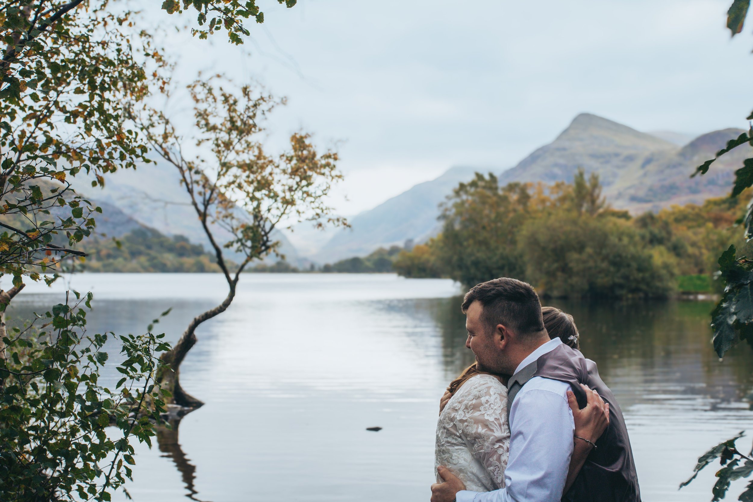 A couple embracing beside a lone tree in a lake