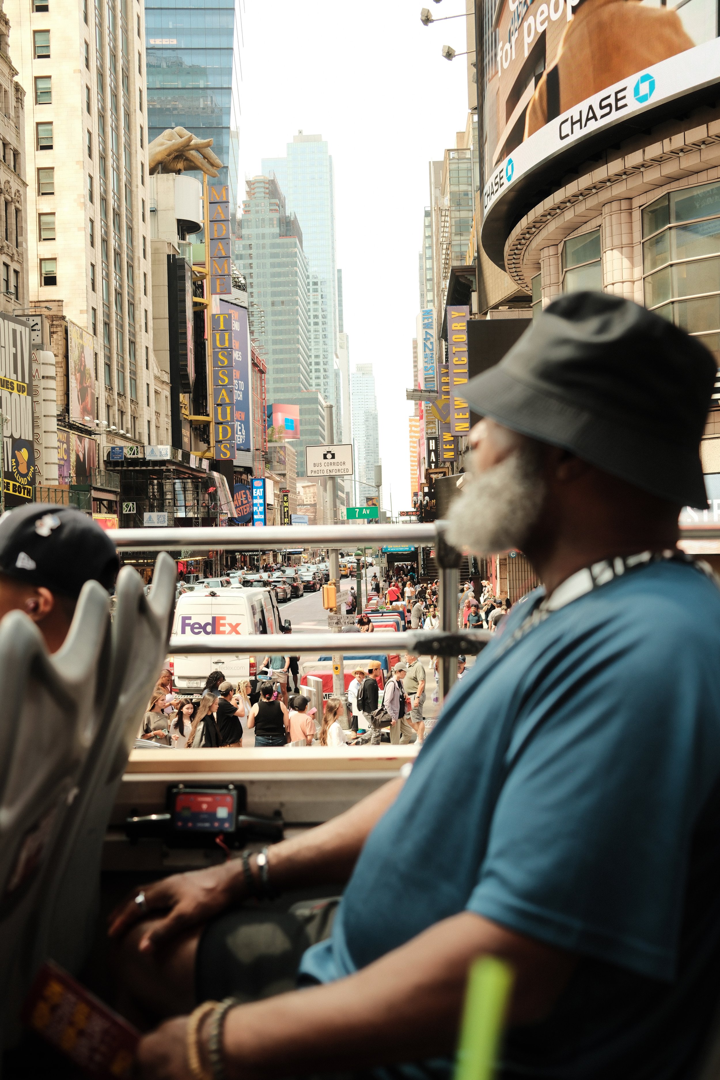 Straatportret van een man met hoed in Times Square, New York.