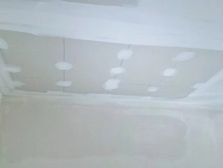 Water-damaged ceiling rebuilt with new drywall, ready for paint