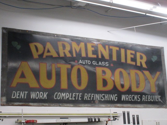 Sign for Parmentier Auto Body advertising auto glass, dent work, complete refinishing, wrecks rebuilt.