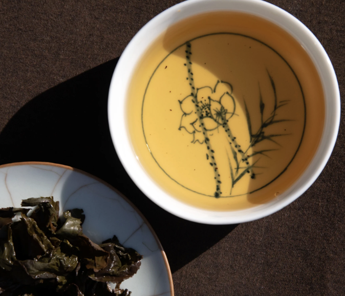Cup of yellow tea with floral branch design, served at Tea with Tyler acupuncture clinic in Longmont, CO
