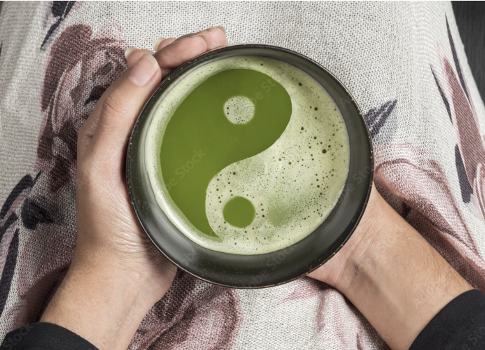 Hand holding matcha latte with yin-yang foam design, Tea with Tyler acupuncture and wellness in Longmont, CO