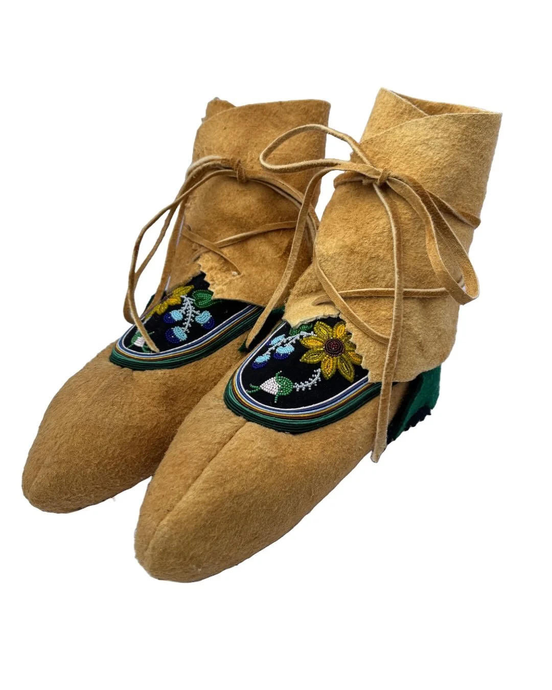 Traditional Metis point-toe moccasins with floral embroidery, made of smoke-tanned Moose leather, featuring beaded decorative panels.