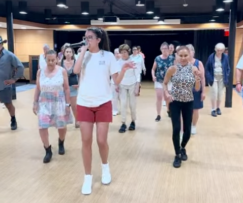 Group of people participating in a line dance class in a studio or community center