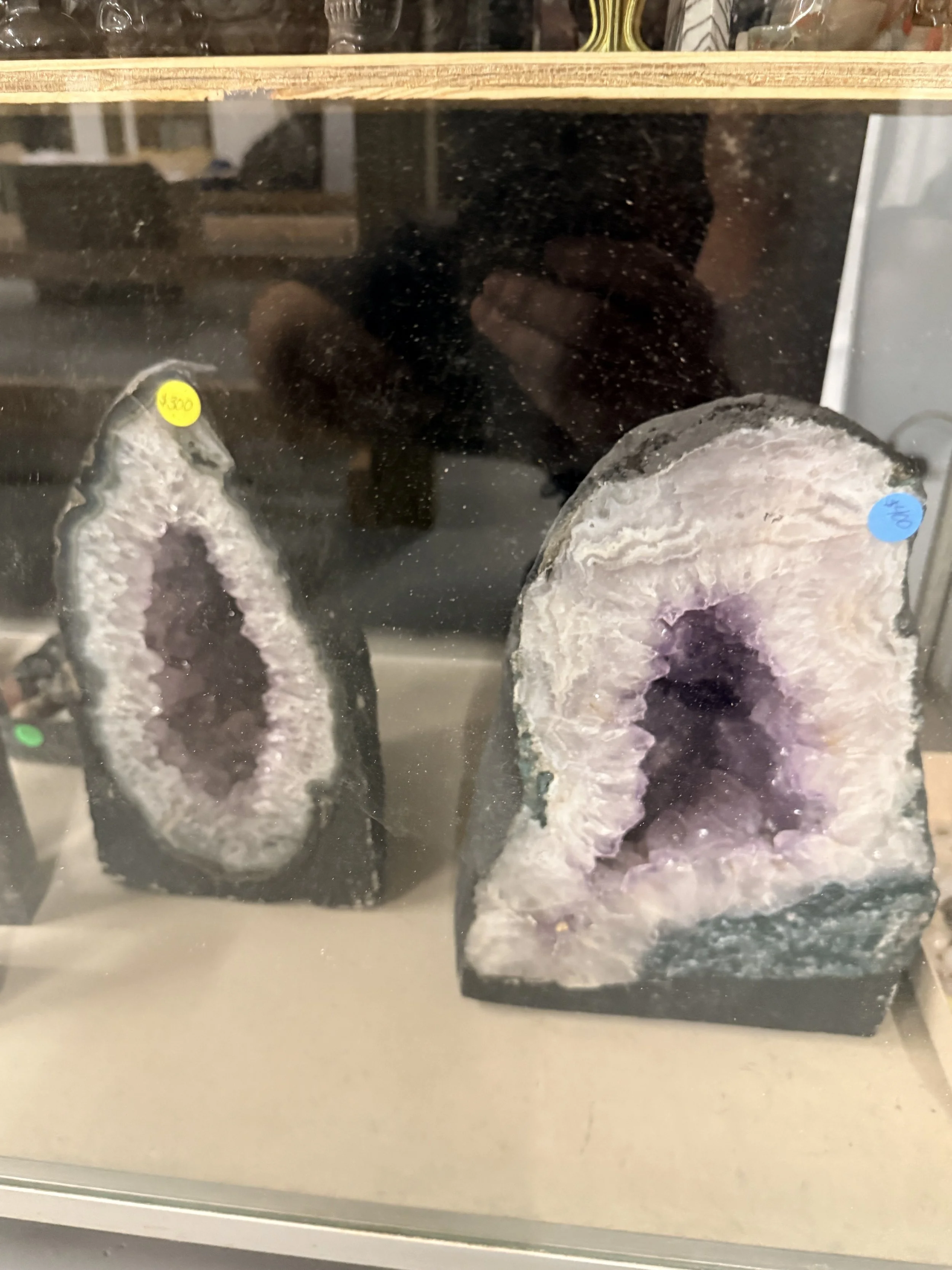 Geode mineral specimens with crystalline interior on display in a glass case.