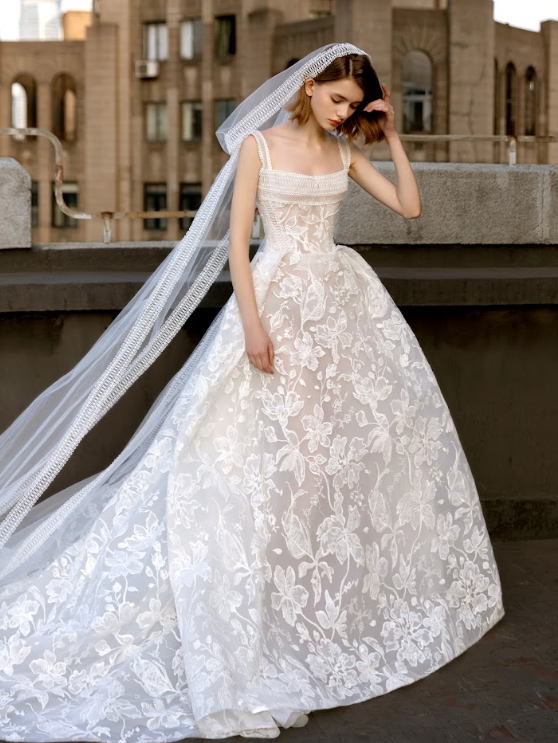 A young woman in a wedding dress and veil on a rooftop.