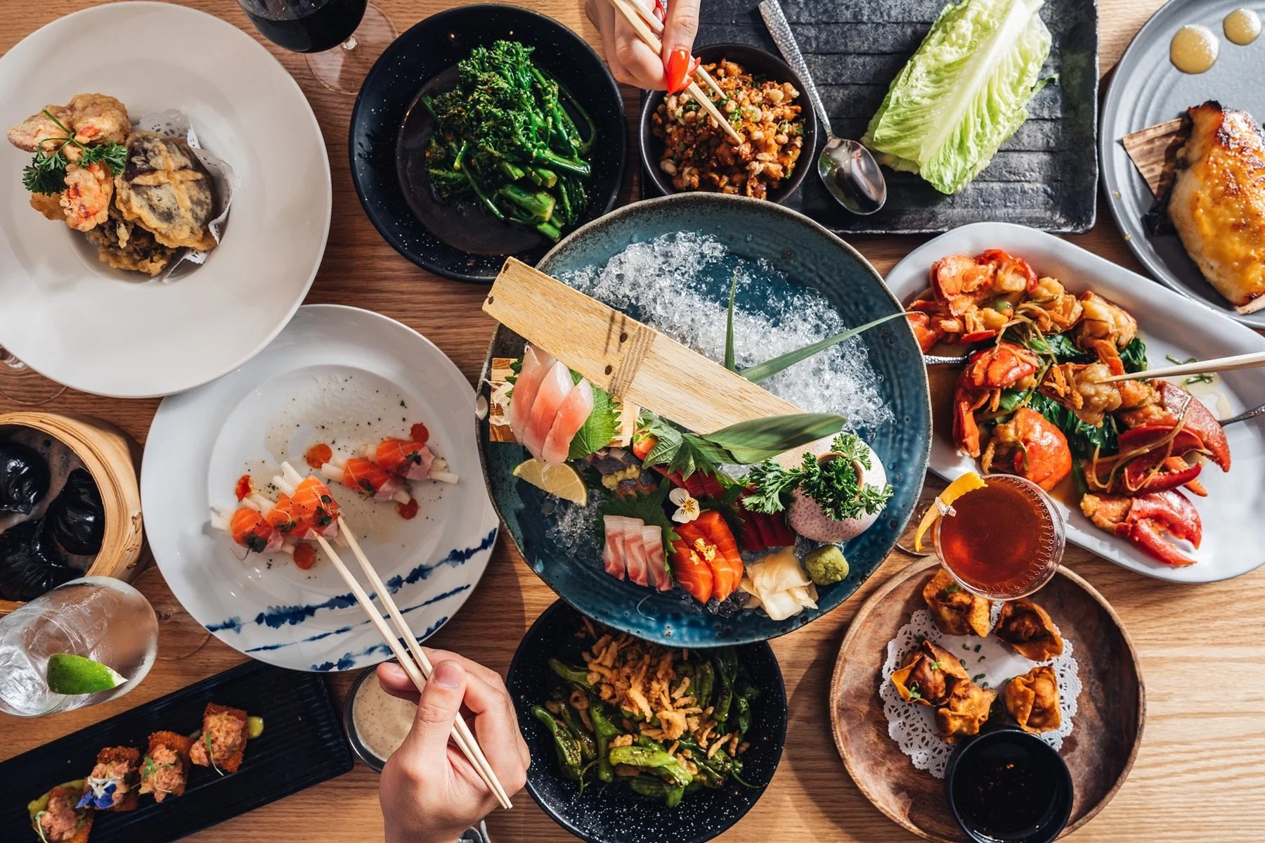 Assorted Japanese dishes at Hinoki Burlington, including sushi, sashimi, fried chicken, vegetables, and drinks.