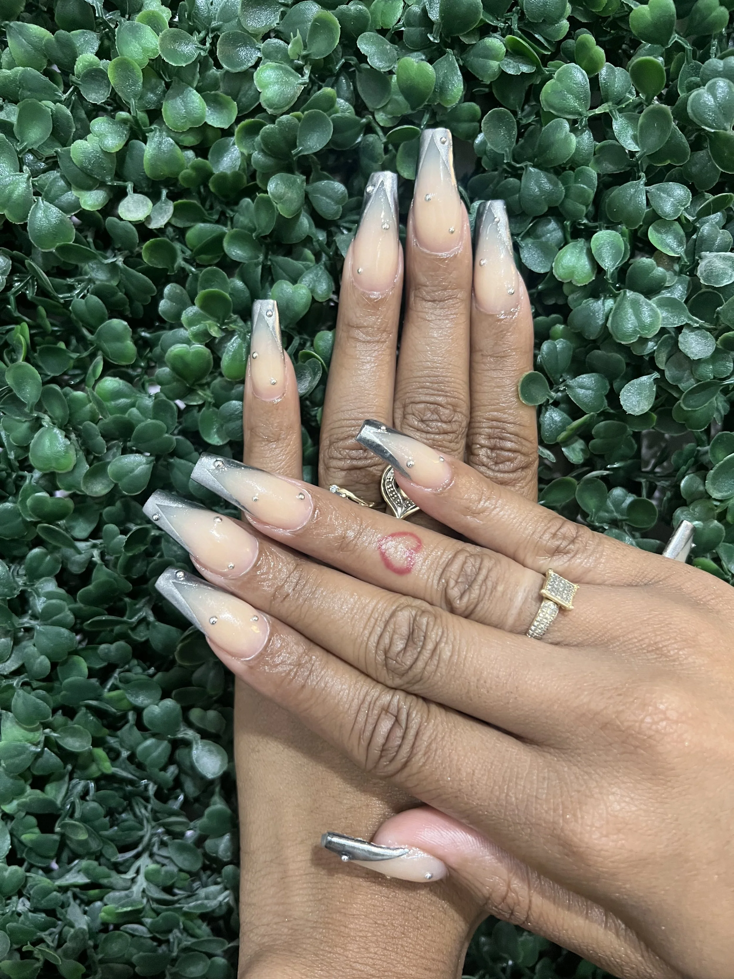 1. Nude coffin nails with silver chrome tips and rhinestone accents.