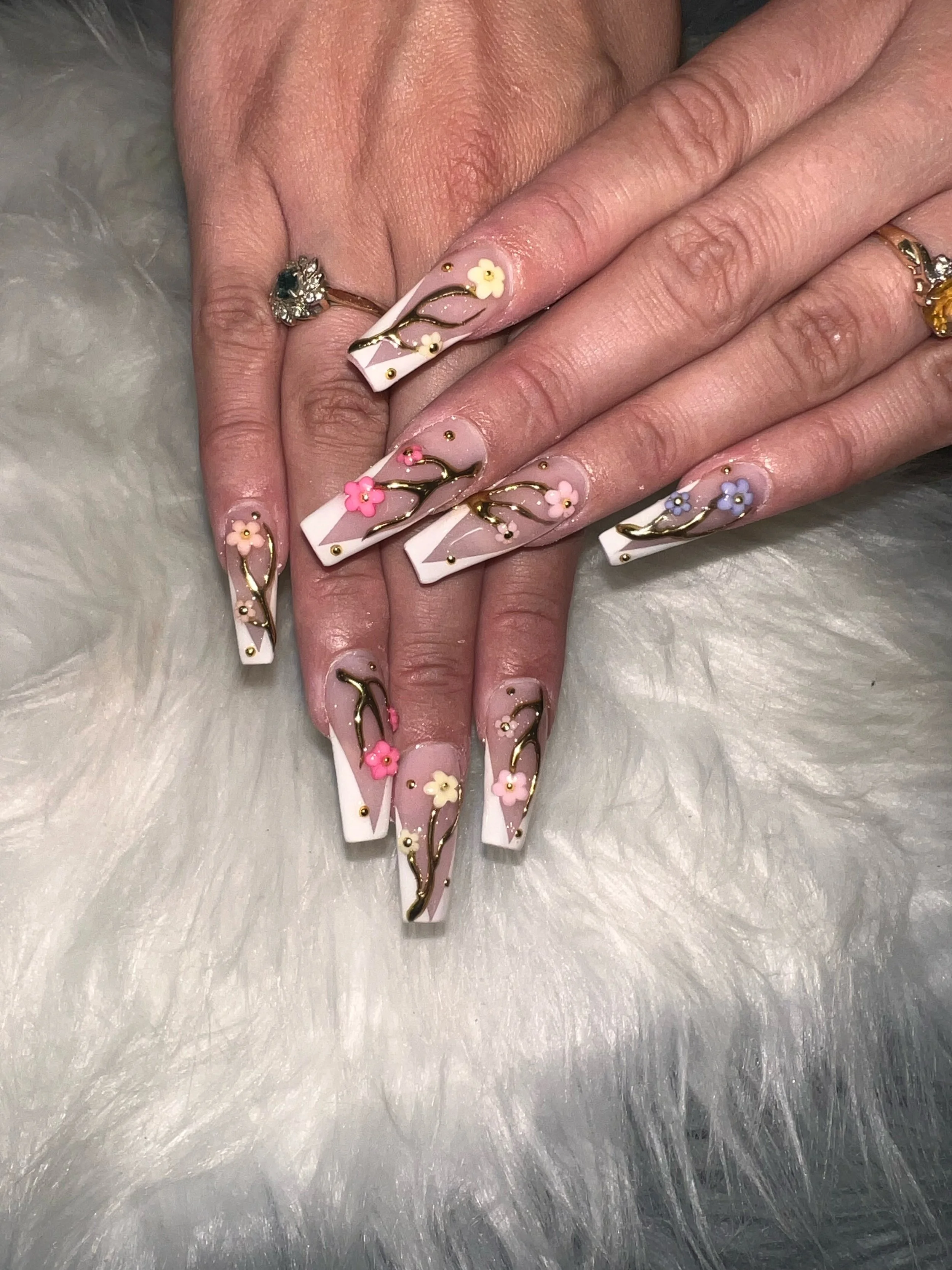 Pink square nails with gold vines and colourful floral accents.