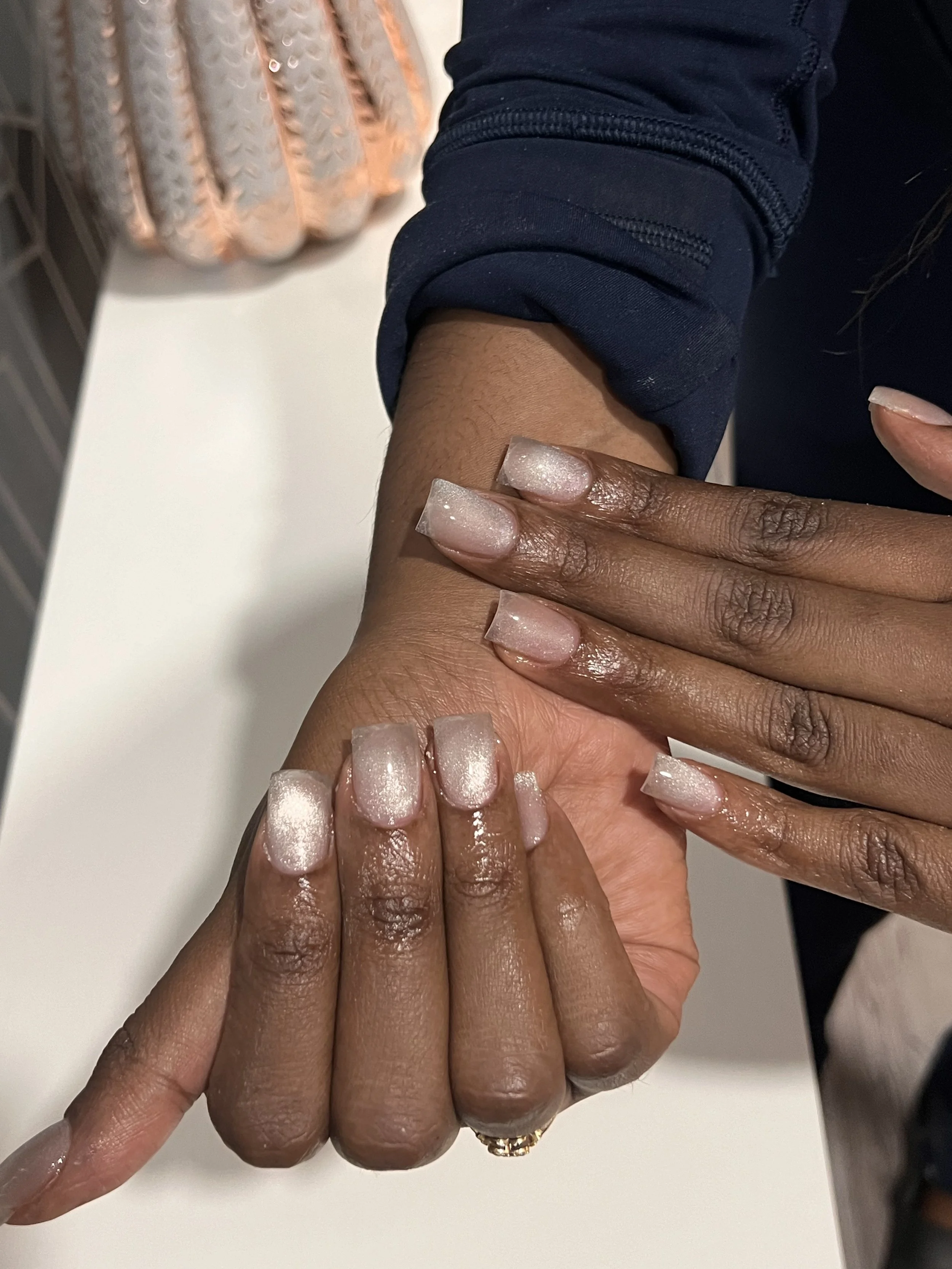 Short square nails with a soft pink shimmer finish.