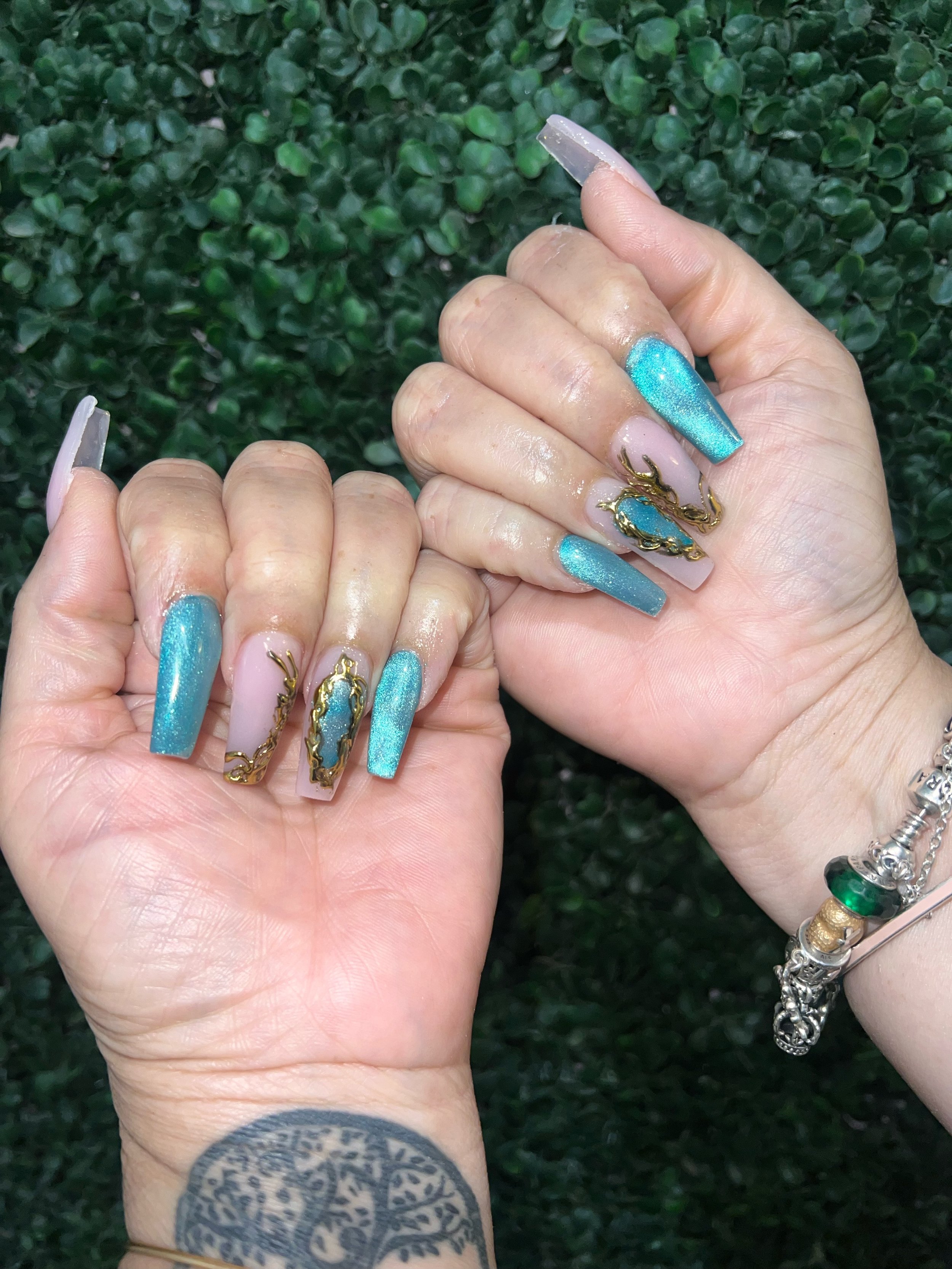 Turquoise acrylic nails with sculpted gold and jewel accents.