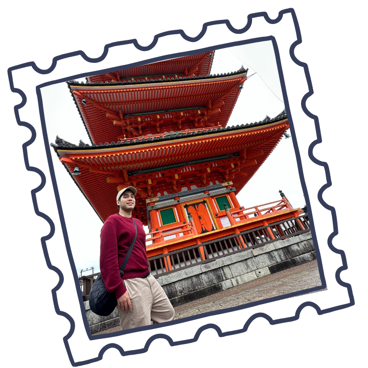 A man standing in front of a traditional Japanese pagoda.