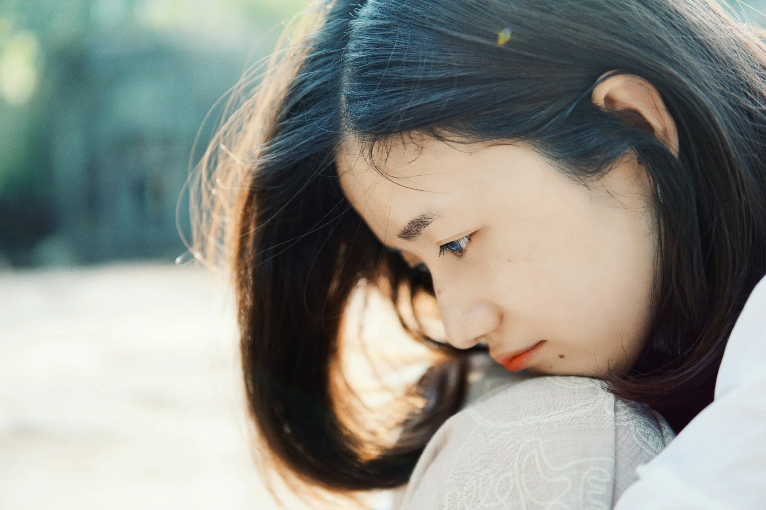 Woman leaning against soft white fabric, deep in thought, considering counselling in Brantford, Ontario