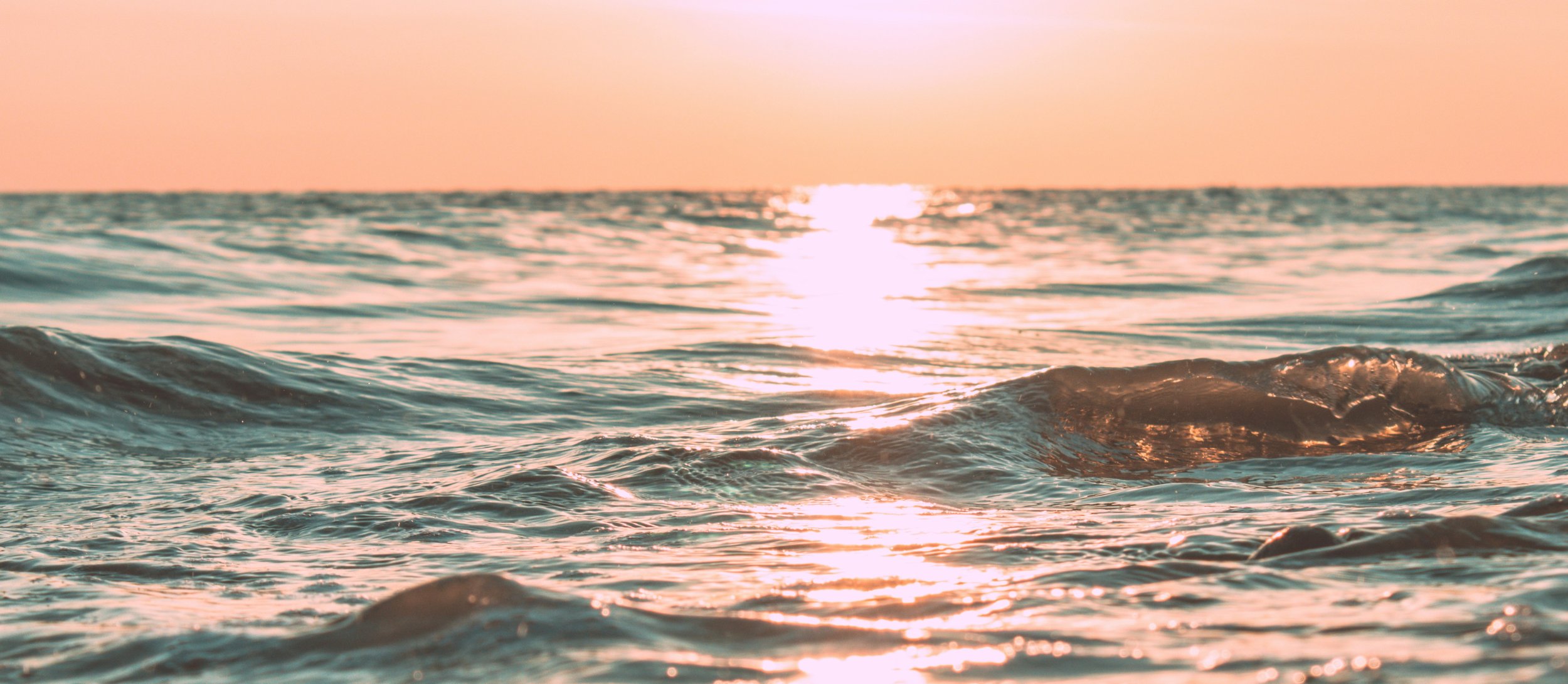 Sunset reflecting on gently rolling ocean waves