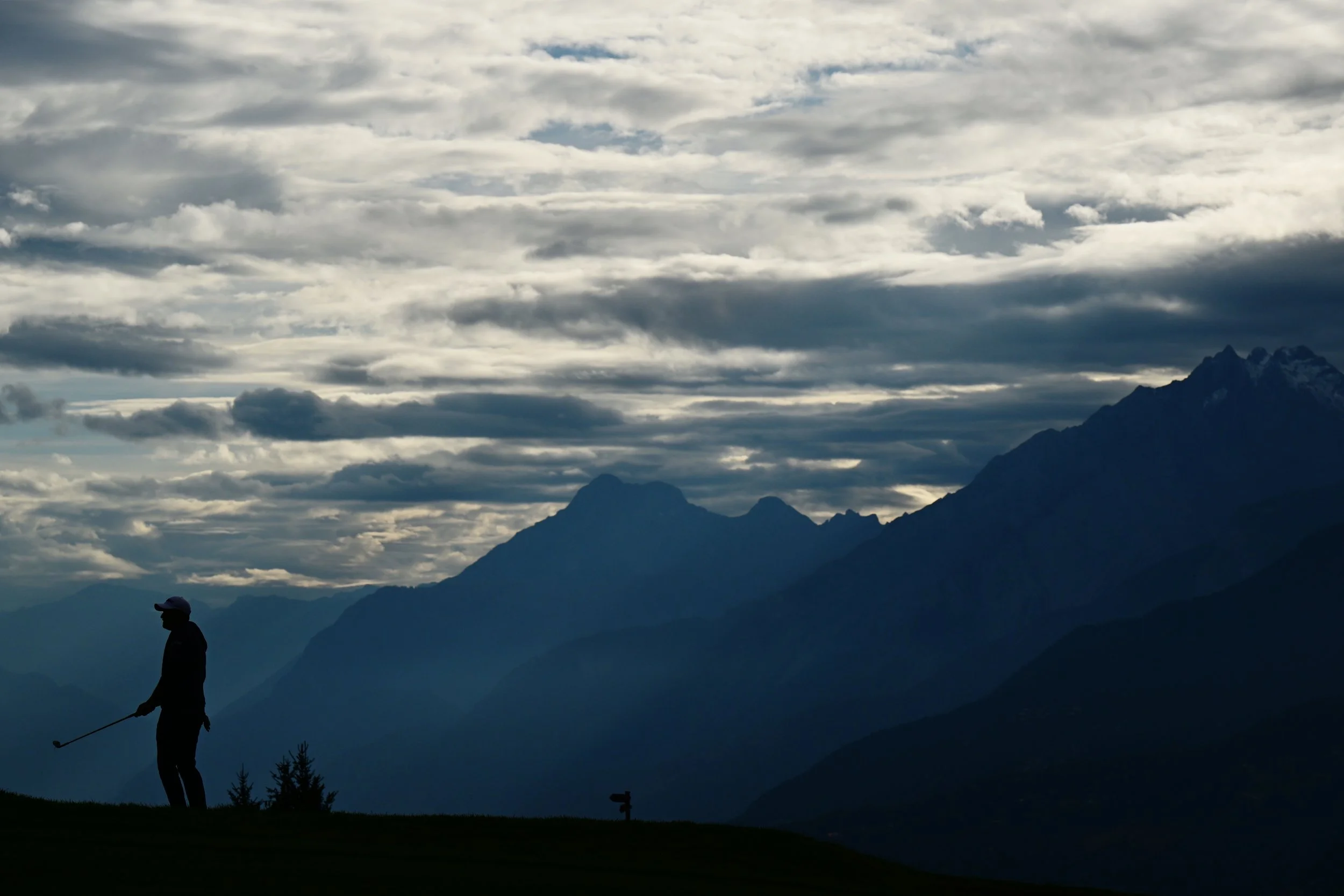 Gunner Wiebe playing golf with Swiss Alps in the backgorund