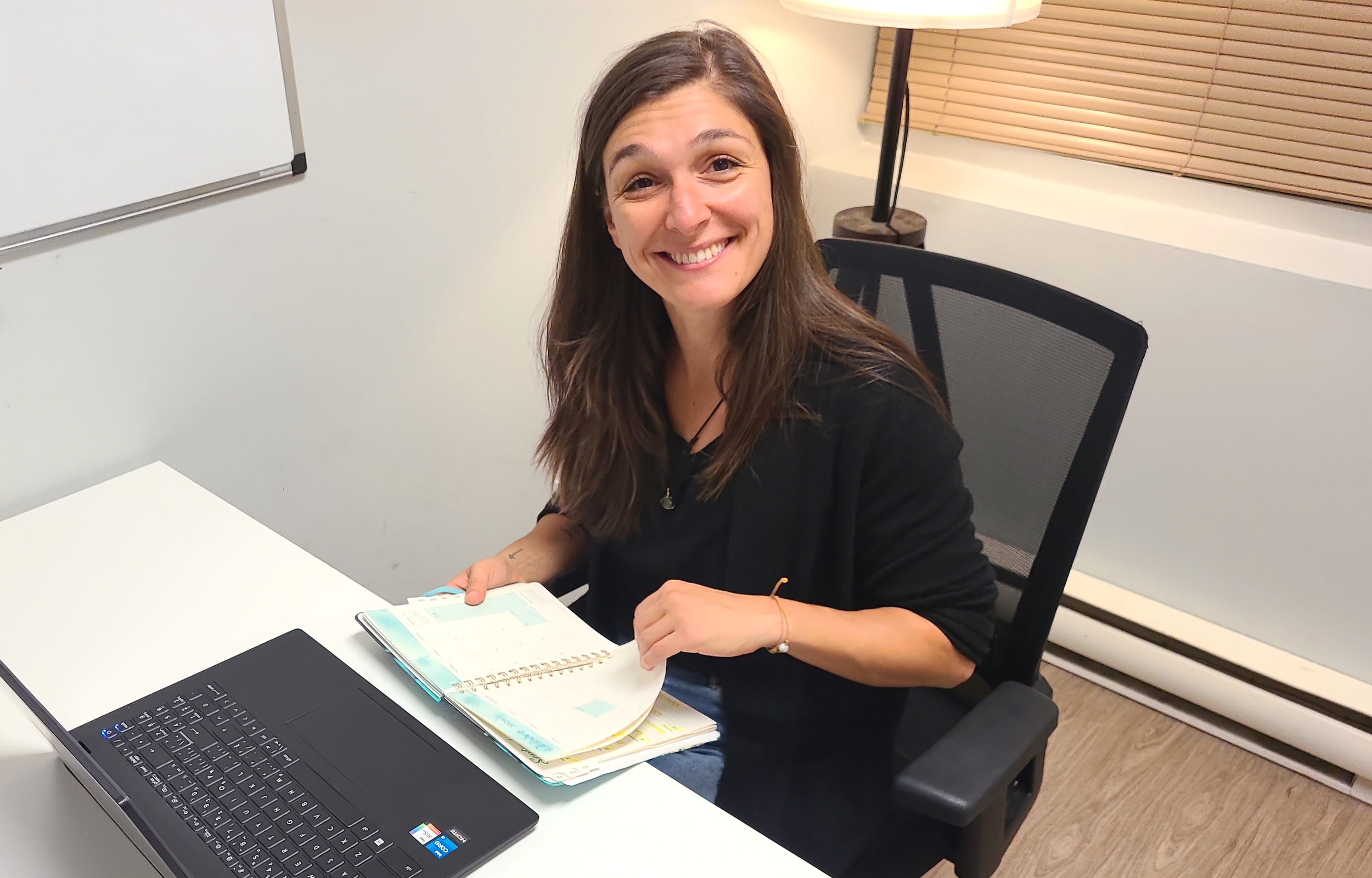 Sarah Guay-Lacombe assise a un bureau, planifiant ses rencontres dans son agenda