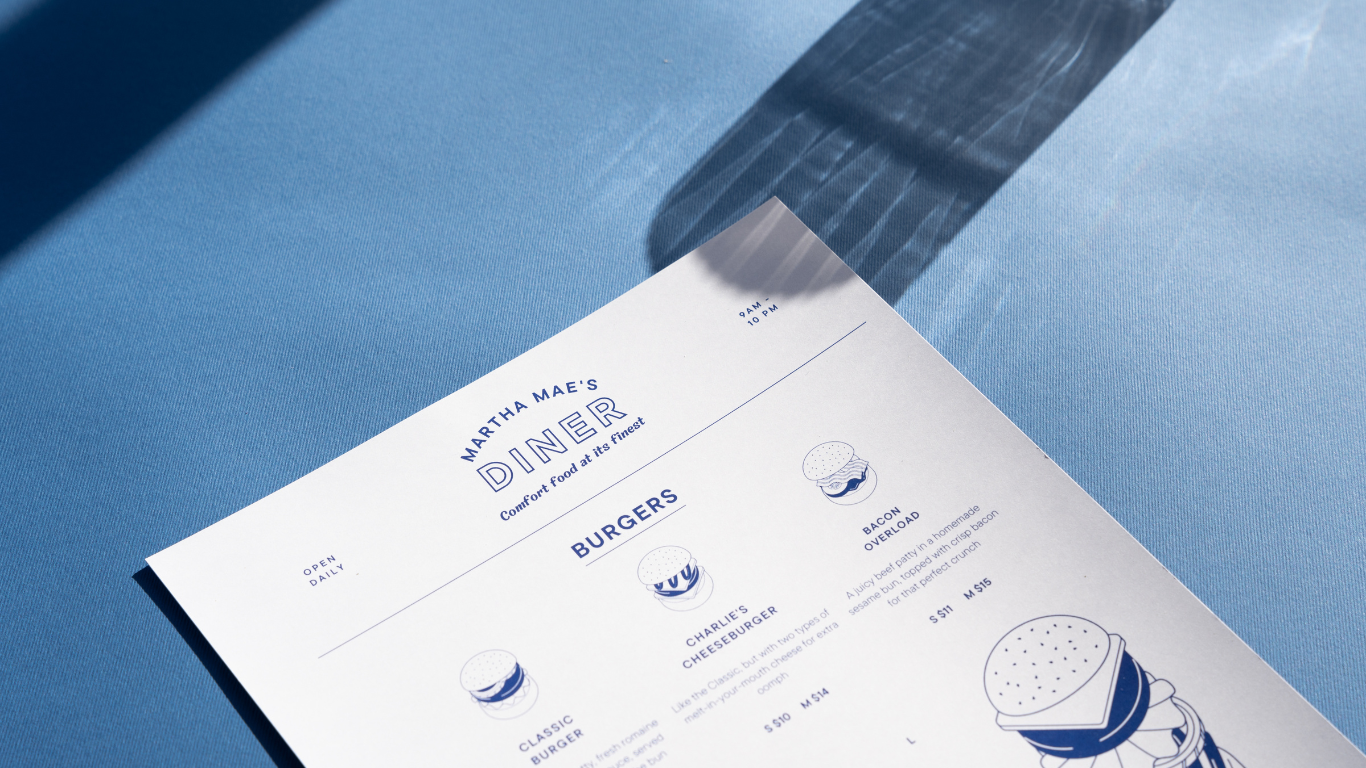 A menu from Martha Mae's Diner with burger options and prices on a blue table under sunlight.