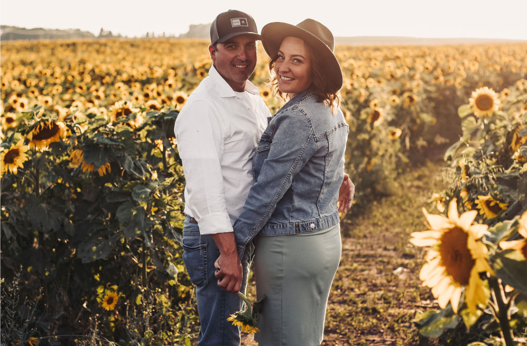 Anna Tonery and her partner John together in a sunflower field in Alberta.