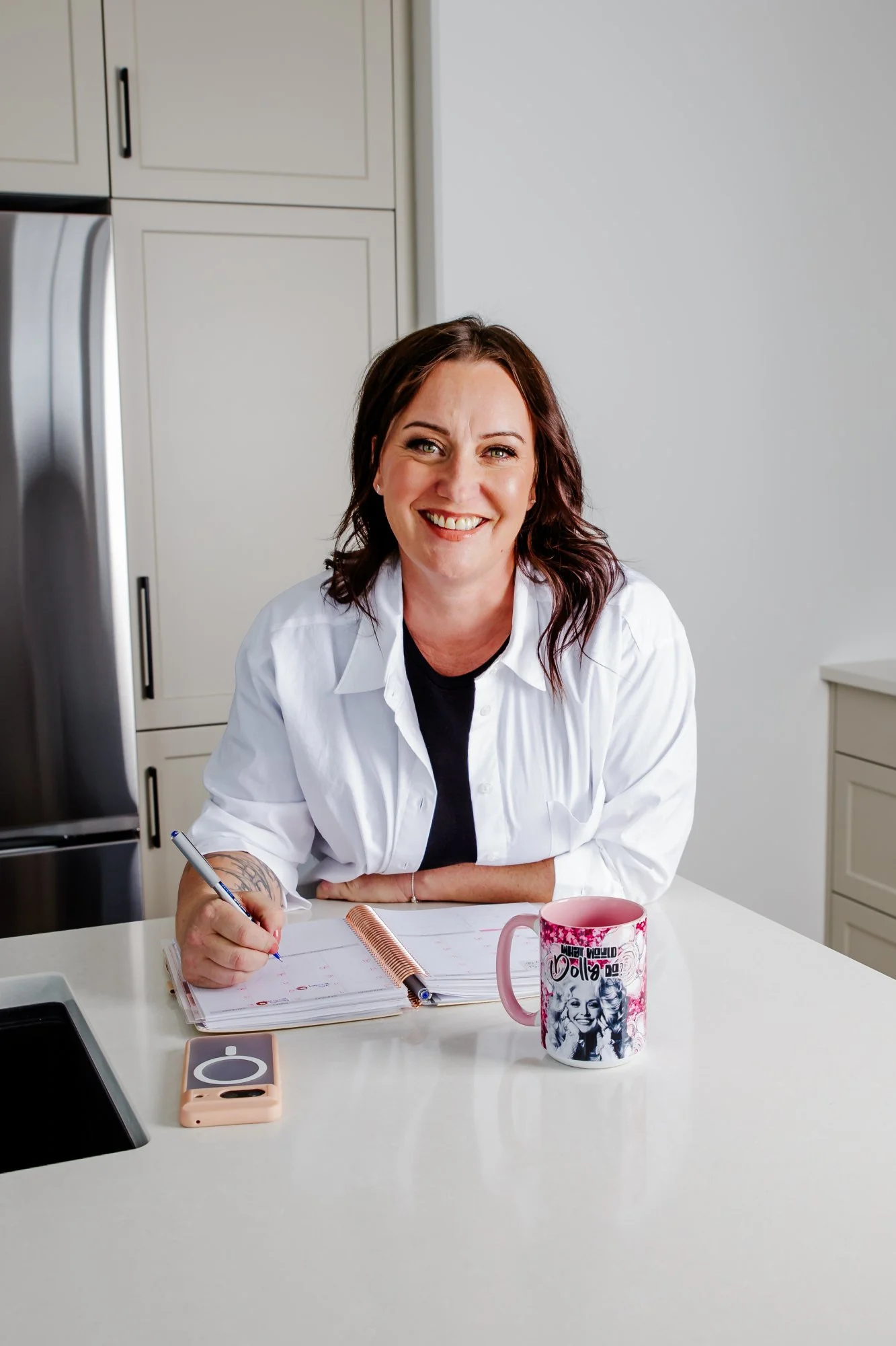 Anna Tonery of Mortgage with Anna working at her kitchen table with a notebook and coffee.