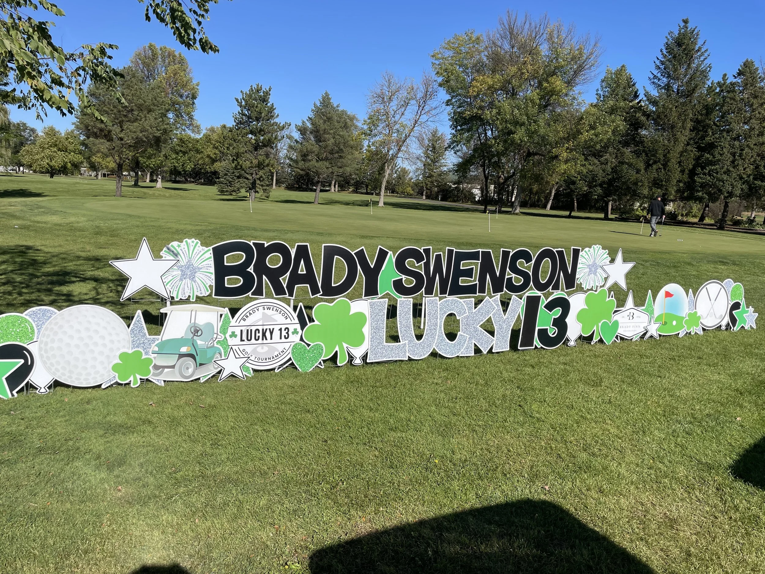 Signage celebrating the Brady Swenson annual Lucky 13 Golf Tournament at Pheasant Acres Golf Course in Rogers, Minnesota.