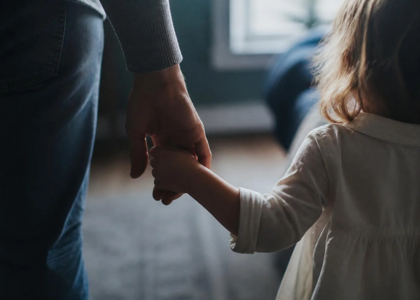 Parent holding child's hand in a medical setting