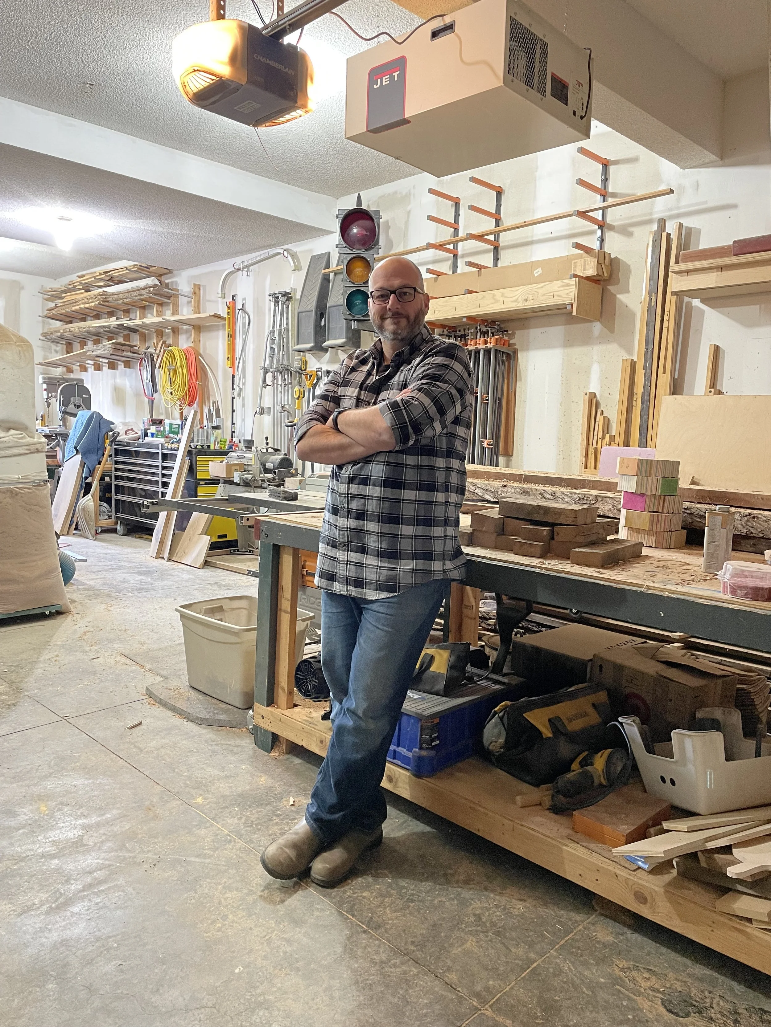 Jake, owner and builder at JK Table Co., standing in his woodworking shop