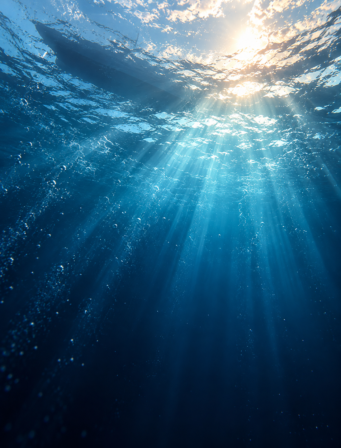 Sunlight filtering through deep blue ocean water beneath the surface.