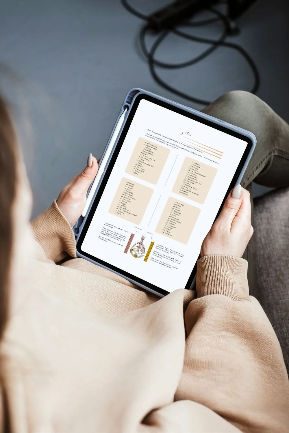 Person holding a tablet with a document and learning about human design.