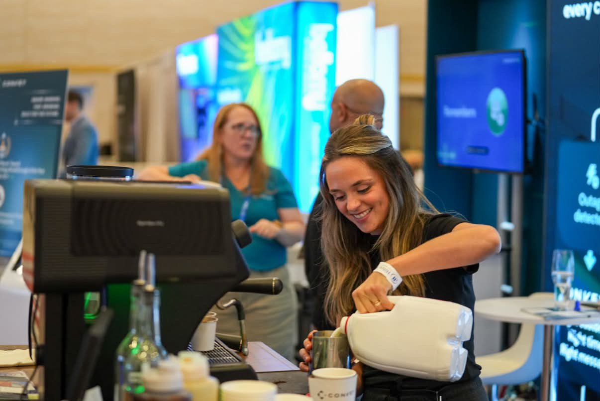 Hebrews Coffee Co. barista pouring steamed milk at a conference espresso bar